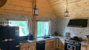A kitchen with wooden cabinets, a built-in oven, a sink, and a coffee maker.