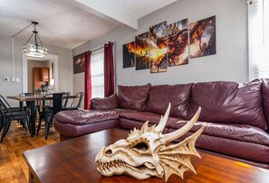 Relax in this stylish living room with a comfortable sofa, wooden coffee table, and dining area.