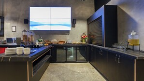 A modern kitchen with a large island, built-in appliances, and a large window displaying a scenic view.