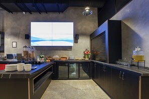 A modern kitchen with a large island, built-in appliances, and a large window displaying a scenic view. - The Viv Hotel (Wellington)