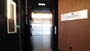 A hallway with a closed elevator and a sign indicating it is part of the Marsden Group of Companies.