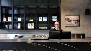 A reception desk with a sign labeled 'RECEPTION' and a person seated behind it.