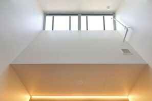 A modern, minimalist room with a large window, a desk, and a chair. - The Viv Hotel Wellington (Wellington)
