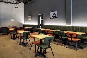 A restaurant interior with booths and tables, some with chairs, and a wall with a door labeled 'STAFF ONLY'. - The Viv Hotel Wellington (Wellington)