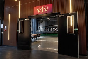 A hotel entrance with a reception desk, a seating area, and a sign indicating a fire door.