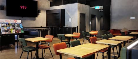 Un restaurante moderno con una televisión de pantalla plana mostrando 'VisitorPoint' y un letrero que dice 'The Hotel IV'.