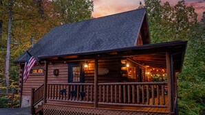 Una baita di legno con un portico, una bandiera americana e un cartello che indica un ristorante.