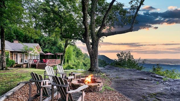A cozy outdoor seating area with Adirondack chairs and a fire pit, overlooking a scenic view of a lake and mountains. - Cloudland Retreat w/ Mountain & Valley Views! (Menlo)