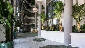 Un amplio atrio con techos altos, ventanas grandes y plantas de interior.
