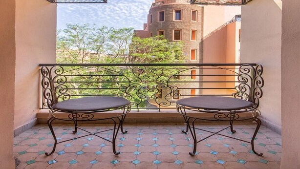 A balcony with two chairs and a decorative metal railing. - Residence Bouroud Hivernage 5376 (Marrakech)