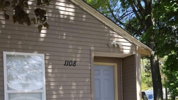 A single-story house with a number '1108' on the side, a front door, and a small porch. - Cute and Cozy (Rockford)