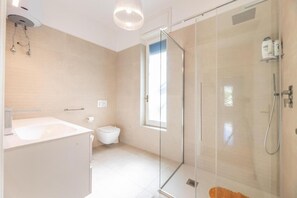 Een douche, een haardroger, een bidet, handdoeken