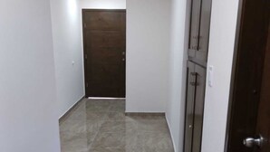 A hallway with a shiny tiled floor, white walls, and a wooden door at the end. - Downtown Oasis: Charming Two-Story Home in the Heart of Puerto Penasco, Mexico!  (Puerto Peñasco)
