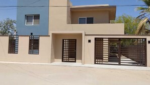 A modern two-story house with a flat roof, a balcony, and a gated entrance. - Downtown Oasis: Charming Two-Story Home in the Heart of Puerto Penasco, Mexico!  (Puerto Peñasco)