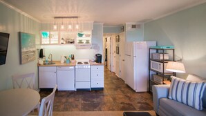 Una cucina funzionale con elettrodomestici bianchi, un tavolo da pranzo e un divano.