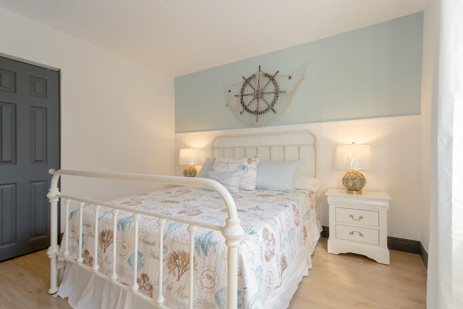Ein Schlafzimmer mit einem weißen Bett, einer Wanddekoration und zwei Nachttischlampen.