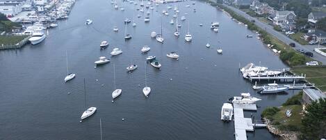 A marina with numerous boats docked along a waterfront, connected by piers and walkways.