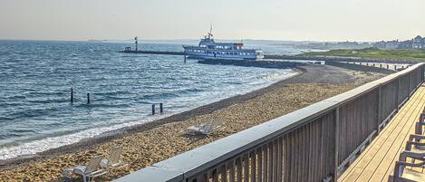 A wooden pier with chairs and a view of the sea.