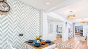 A modern kitchen with a wooden table, white chairs, and a clock on the wall. - Lola Playa by Interhome (Benalmádena Costa)