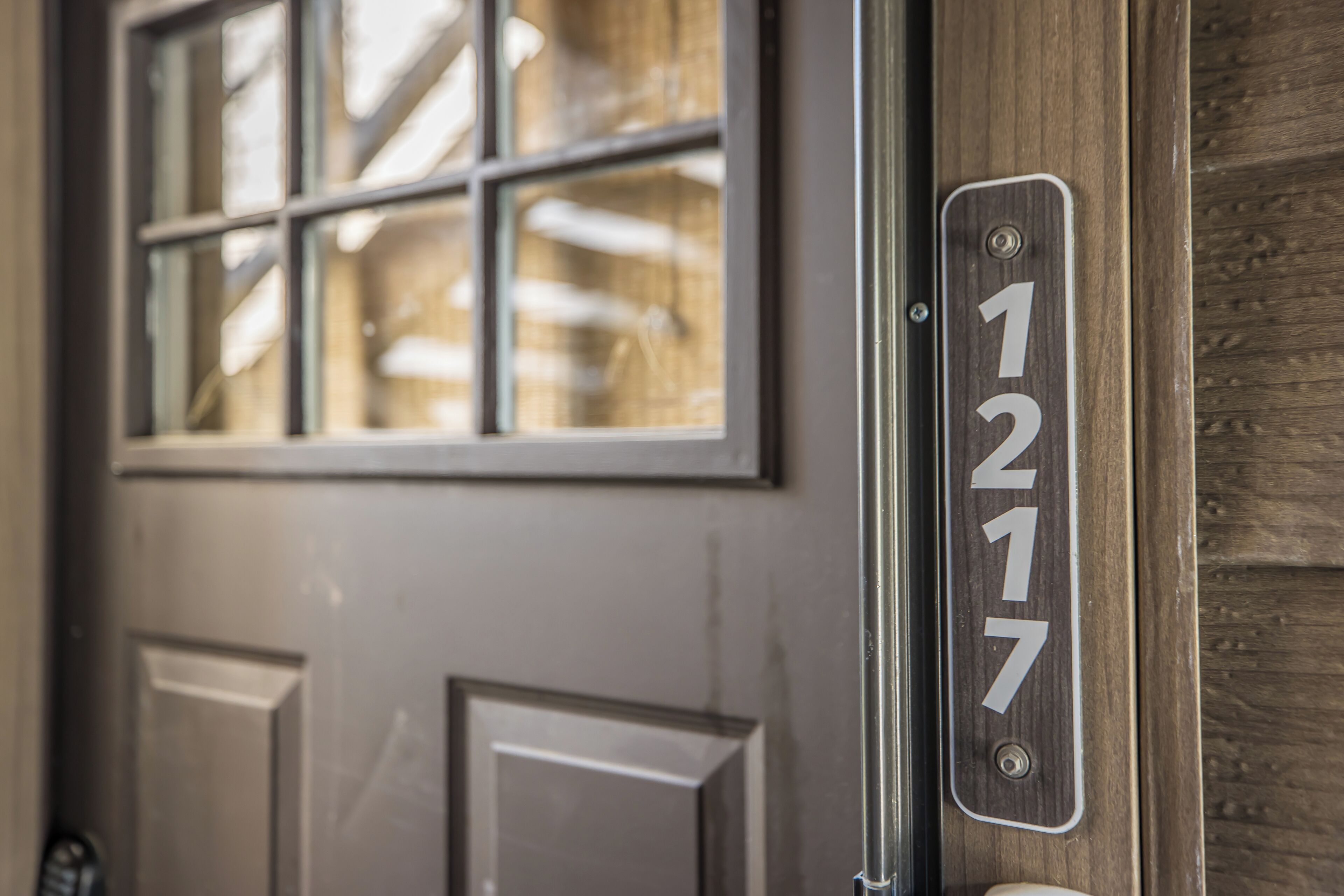 A close-up of a door with a number plate reading "1217" and a window above it.