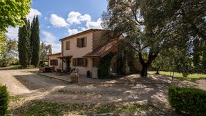 A rustic house with a stone pathway leading to a wooden table and chairs, surrounded by greenery and tall trees. - Appartamento Ciliegia in Tuscan Hills with Shared Pool, Roccastrada, Italy (Roccastrada)