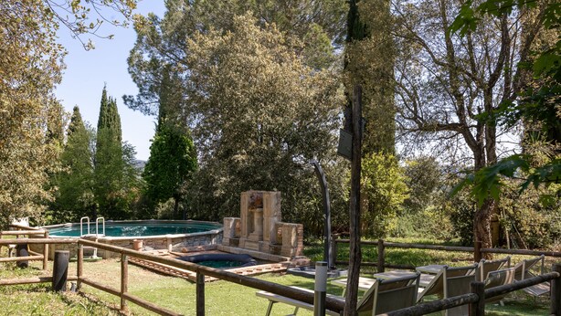 A pool area with a hot tub, lounge chairs, and a stone fountain. - Appartamento Ciliegia in Tuscan Hills with Shared Pool, Roccastrada, Italy (Roccastrada)
