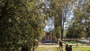 A pathway leading to a stone monument surrounded by trees. - Appartamento Ciliegia in Tuscan Hills with Shared Pool, Roccastrada, Italy (Roccastrada)