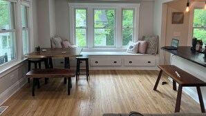 A cozy dining area with a wooden bench, a table, and a built-in bench seat with cushions.