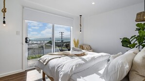 Une chambre avec un grand lit, une vue sur la mer et un balcon.