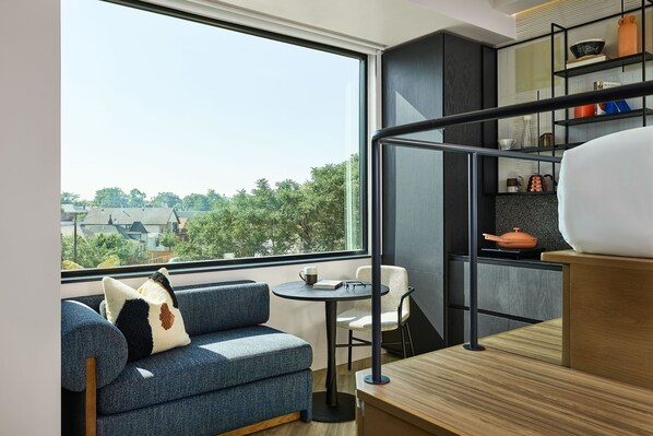 Un interior moderno con un sofá, una mesita y una zona de cocina con estanterías.