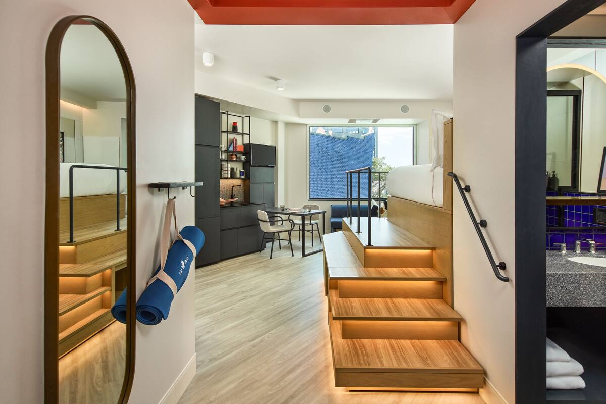 A modern interior with a staircase, a dining area, and a view of the outside.