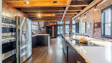 Kamer | Privékeuken | Een koelkast met diepvriezer, een microgolfoven, een oven, een kookplaat