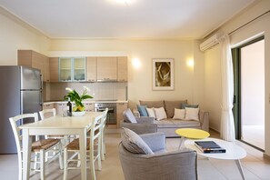 A modern kitchen with a dining area, a sofa, and a coffee table.