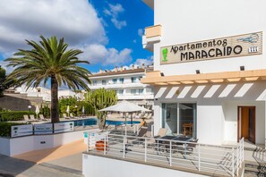 A hotel named 'Apartamentos Maracaito' with a pool area, outdoor seating, and a view of the surrounding buildings.