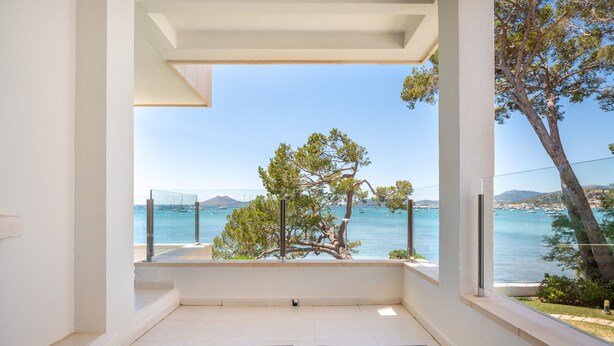 Ein Balkon mit Blick auf Meer und Berge.