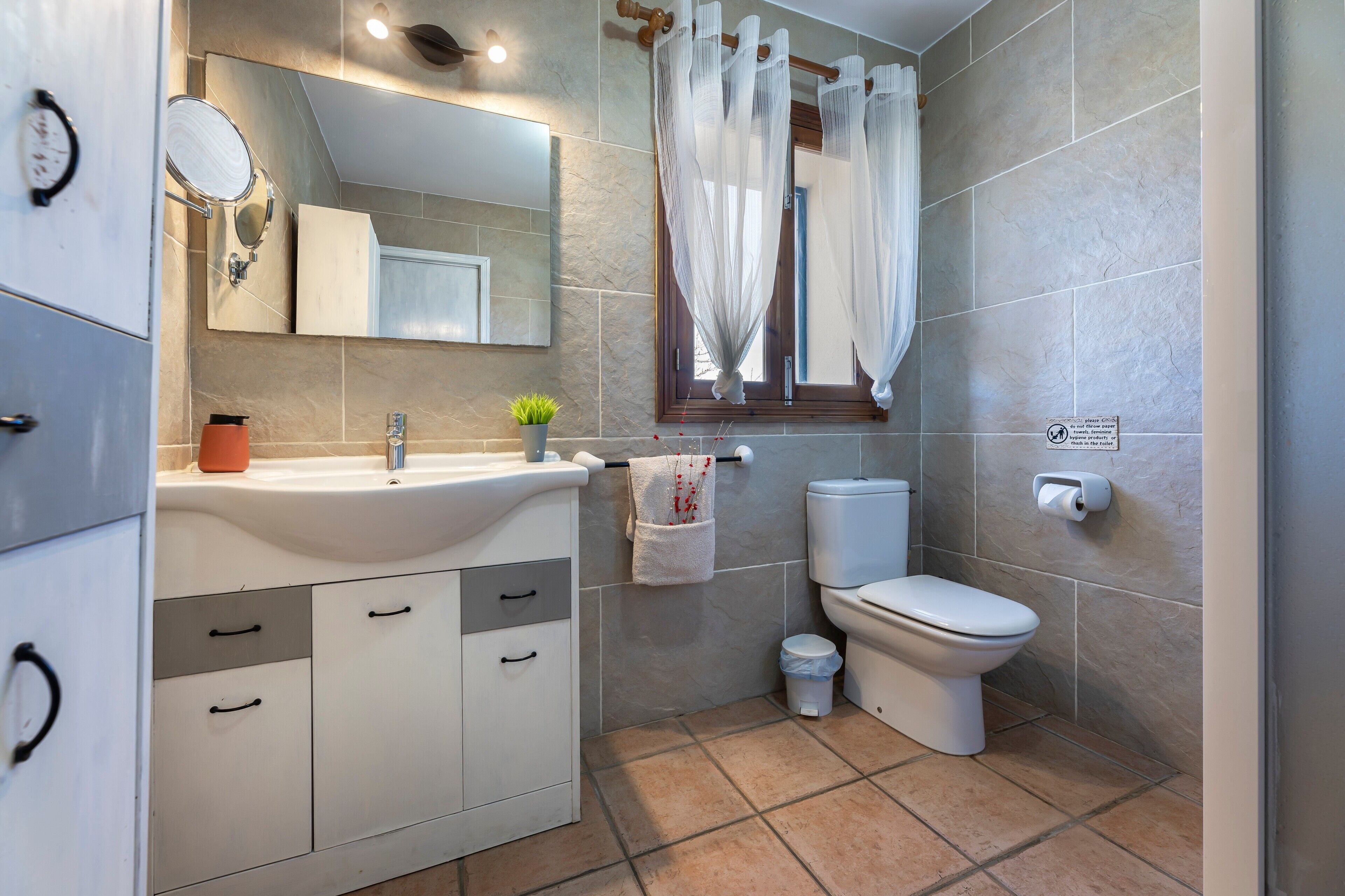 Un baño con lavabo, espejo, inodoro y cortina de ducha.