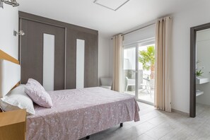 A bedroom with a bed, a chair, a sliding glass door to a balcony, and a mirror. - Holiday Apartment "Nerja Luxury" with Sea View, Terrace & Wi-Fi (Nerja)