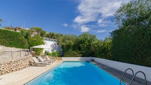 A rectangular swimming pool with a metal ladder, surrounded by a stone wall and a white fence. - Vacation Villa "Villa Diani" with Pool, Wi-Fi, Garden & Terrace (Binibequer)