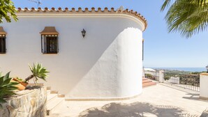 A white building with a curved facade, stone steps, and a view of the sea. - Villa "Natalia" with Sea & Mountain View, Private Pool, Air Conditioning & Terrace (Nerja)