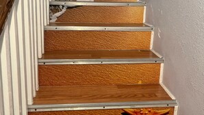 Eine Holztreppe mit einer Meerstern-Dekoration auf der untersten Stufe.
