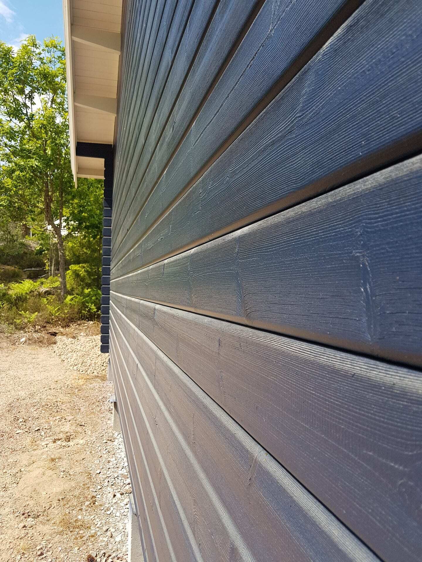A close-up of dark wooden siding on a building's exterior.