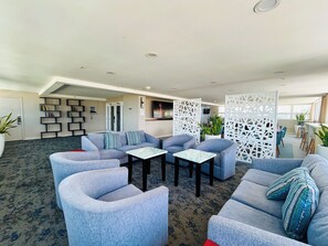 A modern living room with a sectional sofa, armchairs, a coffee table, and a decorative partition. - "STEPS AWAY FROM THE WAIKIKI BEACH WITH OCEAN VIEW" (Honolulu)