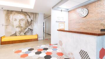 A reception area with a large mural, a clock, and a hexagonal patterned floor.
