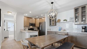 A modern kitchen with wooden cabinets, stainless steel appliances, and a central island.