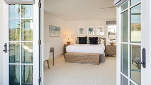 A bedroom with a large bed, bedside tables, a lamp, and artwork on the wall. - "Casa Playa" in the heart of West Beach - impeccably remodeled, with A/C and 2 car garage! (Santa Barbara)