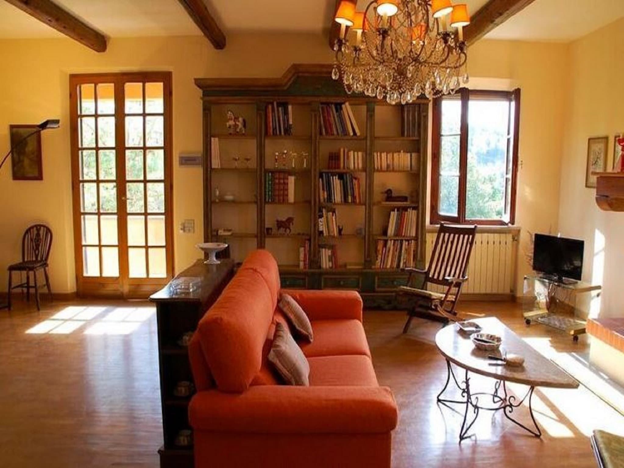 Ein gemütliches Wohnzimmer mit einer großen Bücherwand, einer bequemen Couch und einem Fernseher.