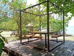 A wooden deck with a swing set, picnic table, and benches. - Reddoorz Plus @ Costa Roca Balamban (Balamban)