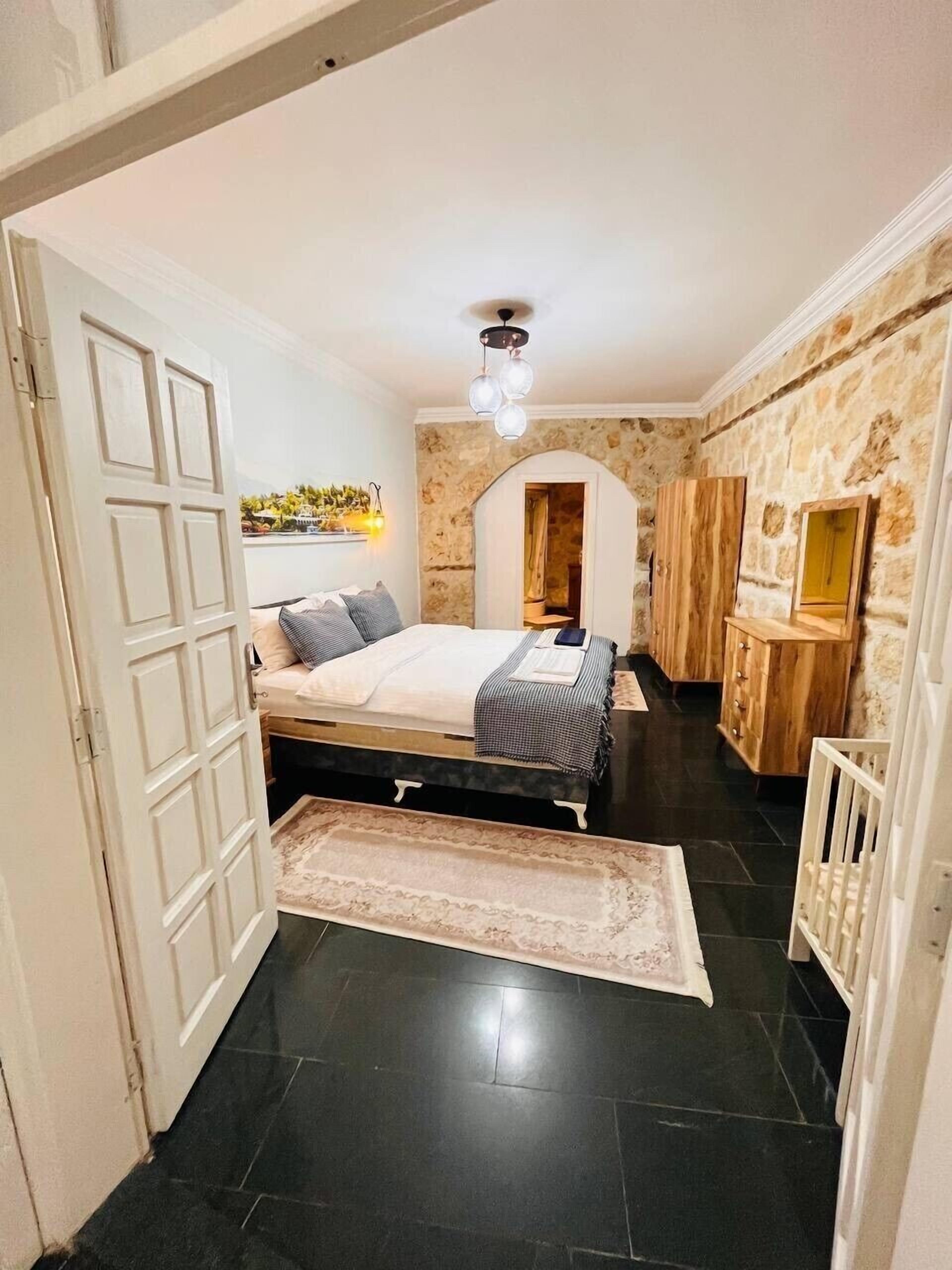 A bedroom with a bed, a wardrobe, and a small desk.