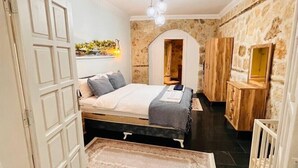 A bedroom with a bed, a wardrobe, and a small desk.