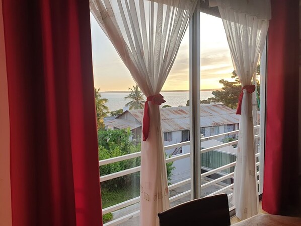 Ein Zimmer mit Blick auf das Meer und Gebäude.